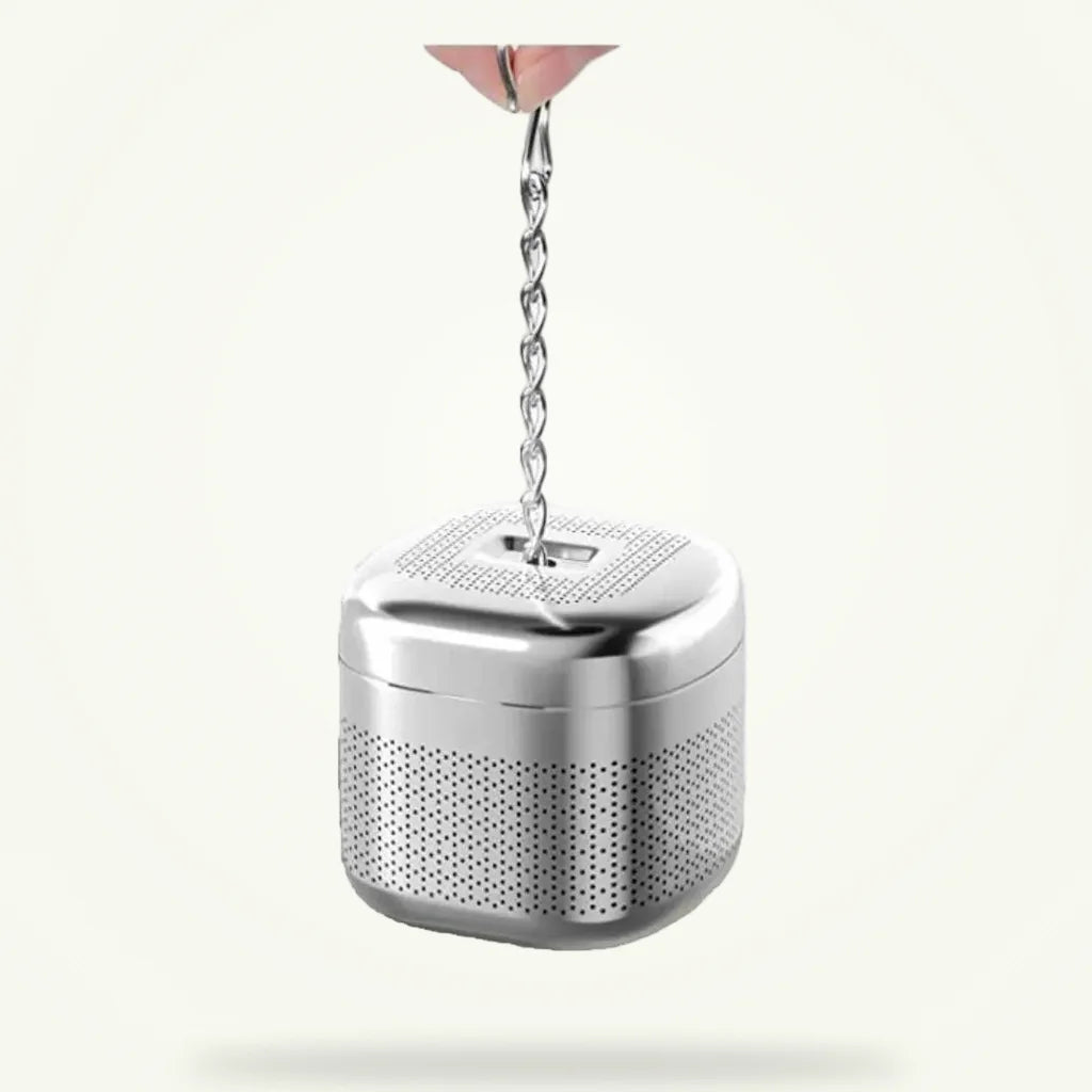 Stainless steel tea infuser cube for loose leaf tea on plain background
