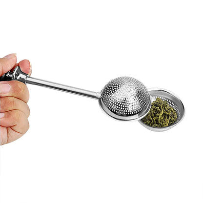 Tea infuser with green tea leaves in a cup