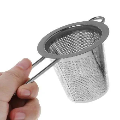 Tea strainer straining loose-leaf tea into white ceramic teacup