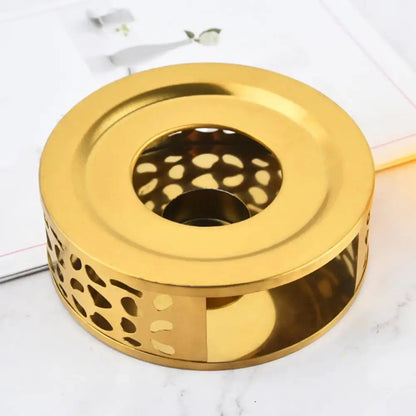 Gold finish stainless steel teapot warmer with warm candle glow visible through open frame