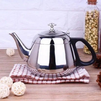 Stainless steel teapot styled on kitchen counter with tea cups