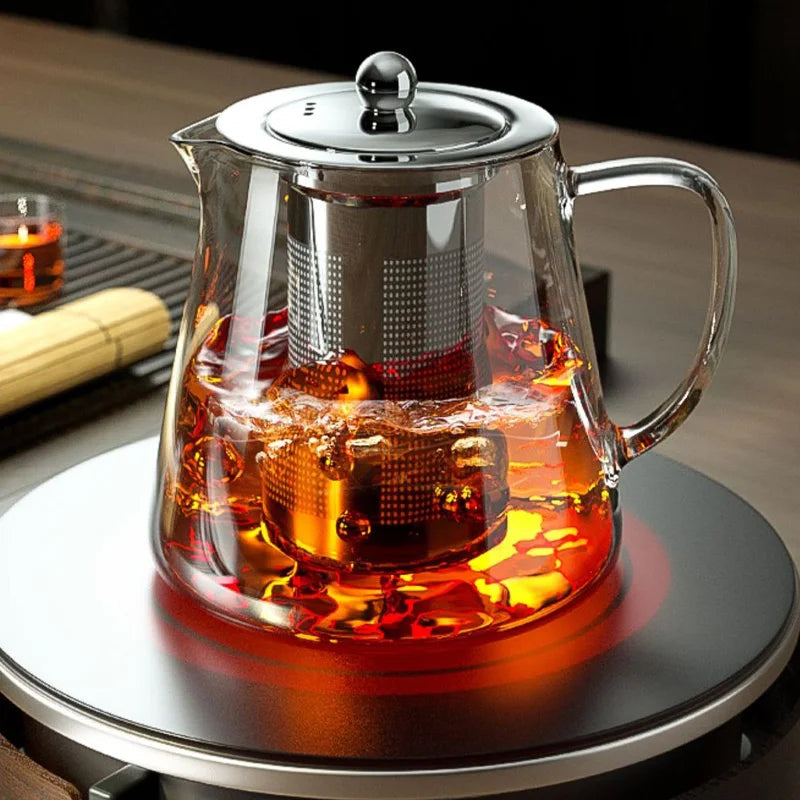 Removable stainless steel infuser basket lifted from the teapot after steeping loose leaf tea