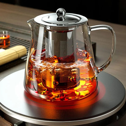 Removable stainless steel infuser basket lifted from the teapot after steeping loose leaf tea