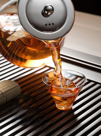 Stainless steel loose leaf teapot with infuser arranged on a wooden serving tray