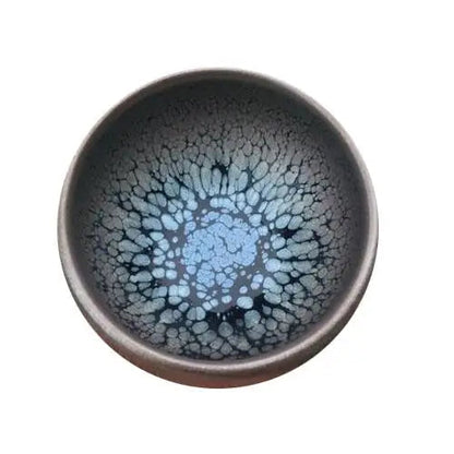 Wheel-thrown tenmoku tea cup with deep dark glaze and natural iron-spot variation