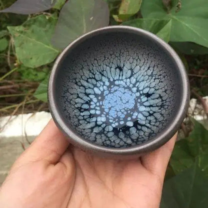Tenmoku ceramic matcha bowl showing dark iron-oxide glaze pooling at base