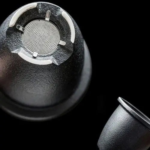 Close-up of removable stainless steel infuser basket inside ceramic teapot