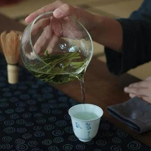 Hand holding glass chawan tea bowl