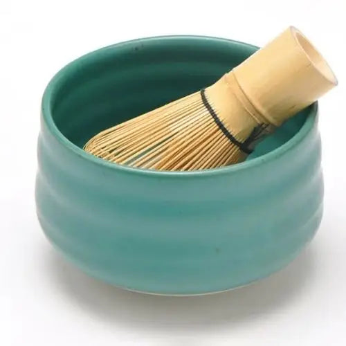 Handcrafted turquoise chawan bowl with tea, side view