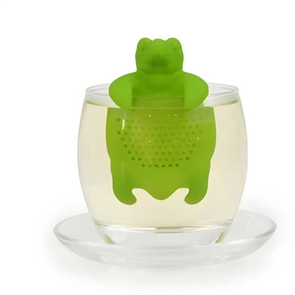 Green silicone turtle tea infuser sitting inside a white ceramic mug