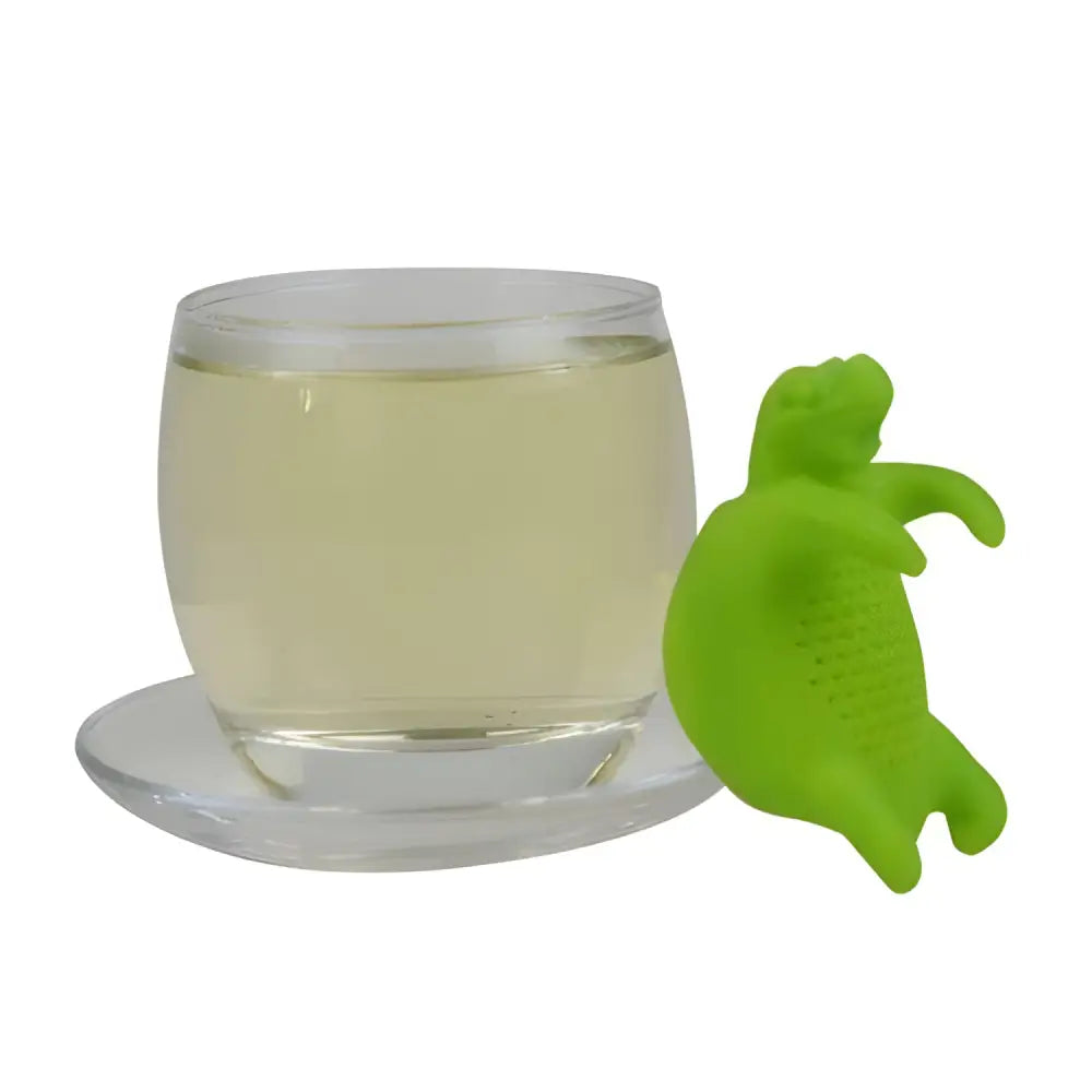Silicone turtle tea infuser resting beside a full cup of brewed tea