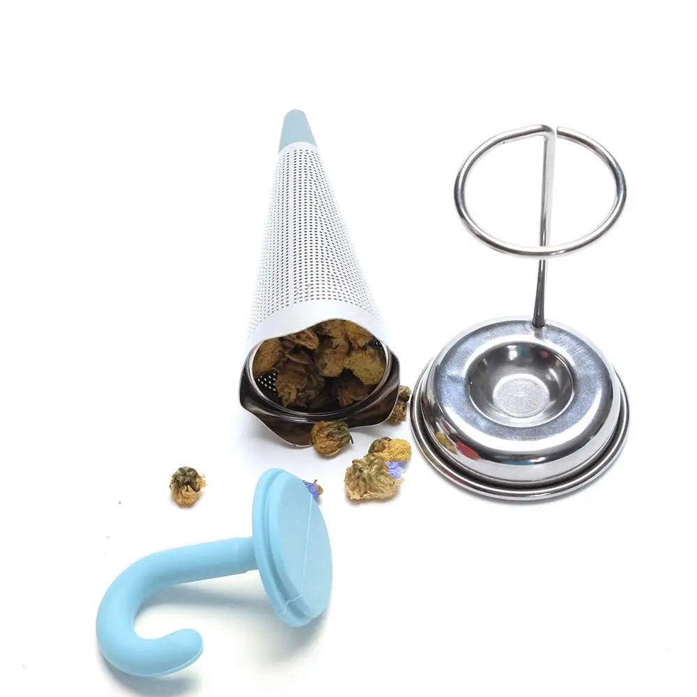 Stainless steel umbrella tea infuser resting on rim of a ceramic mug