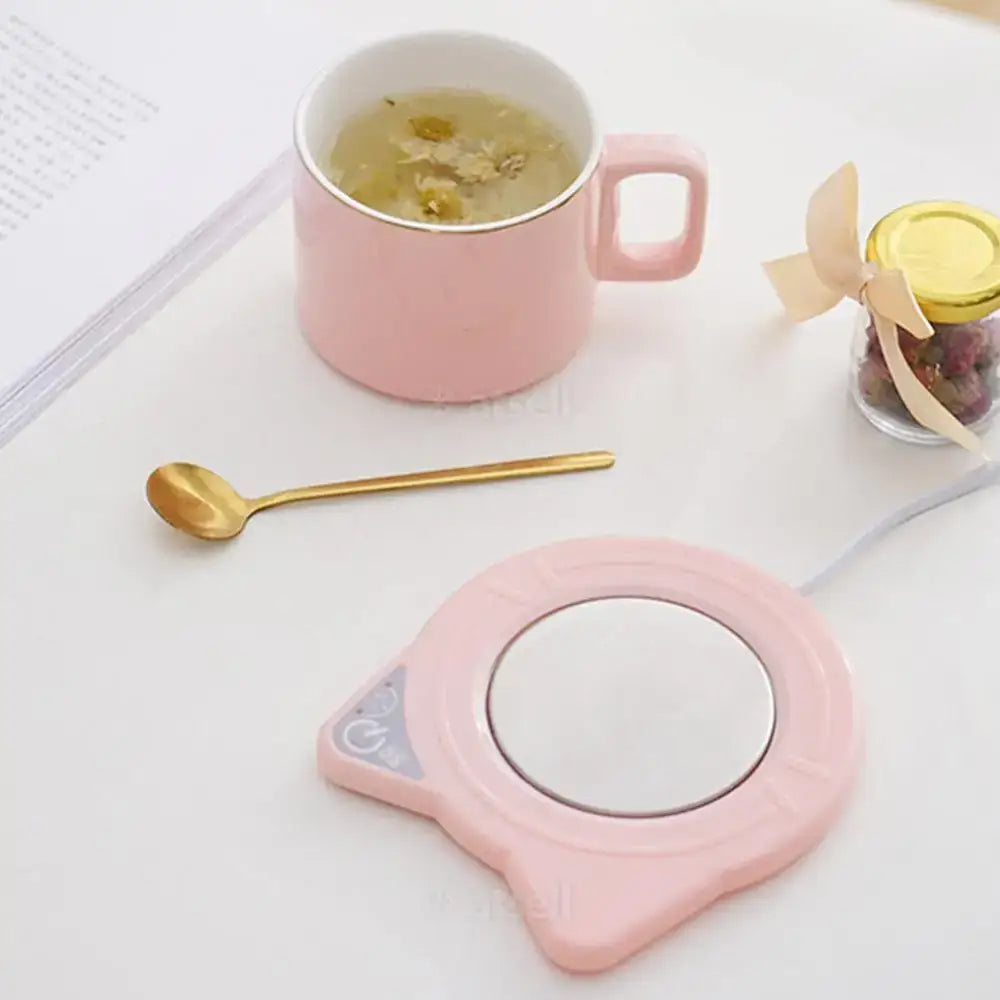 USB cat mug warmer plugged into laptop keeping drink warm