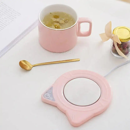 USB cat mug warmer plugged into laptop keeping drink warm