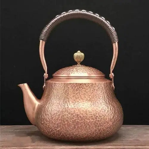 Handcrafted copper tea kettle with big-belly shape on gas stovetop