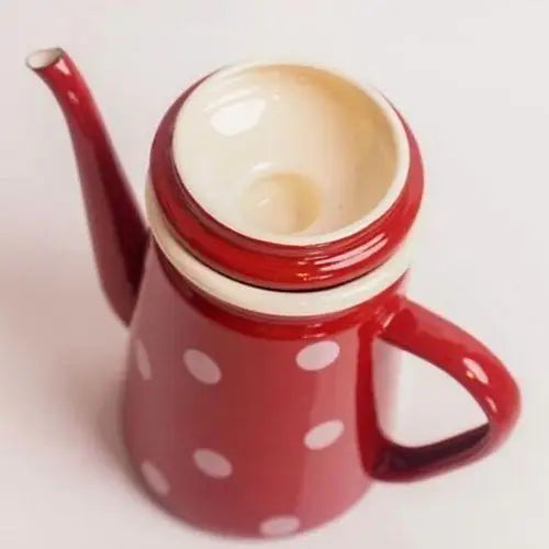 Open lid of vintage red polka dot enamel tea kettle close-up