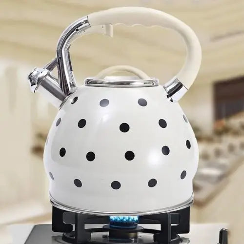 Vintage white polka dot teapot on gas stove