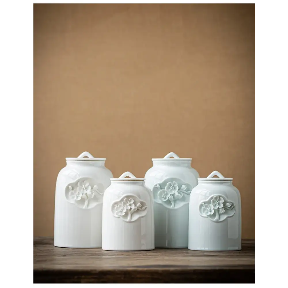 White ceramic tea canister with tea leaves scattered around