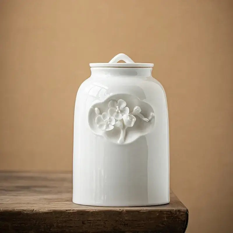 White ceramic tea canister with measuring spoon for loose leaf tea
