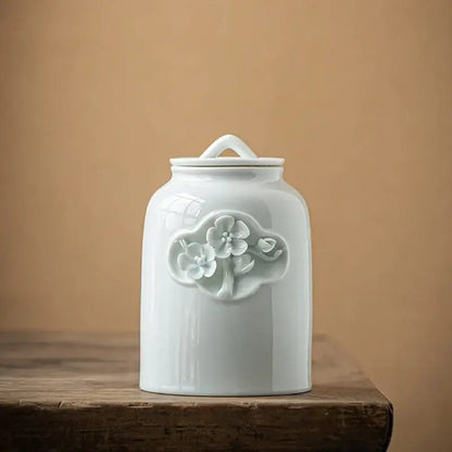 White ceramic tea canister with dried herb and flower decoration