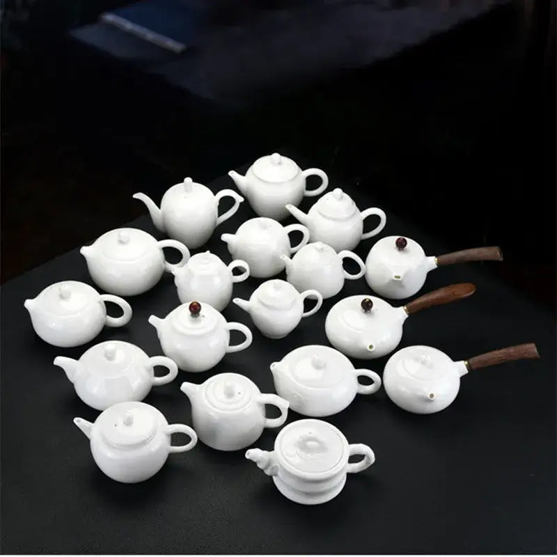 Small white ceramic teapot with cup