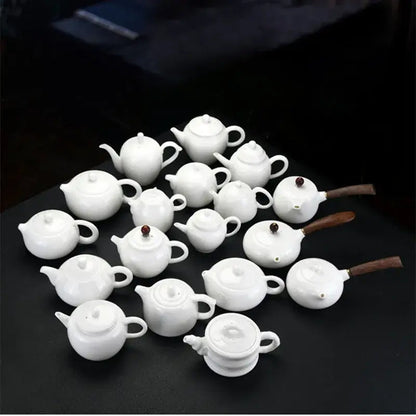 Small white ceramic teapot with cup