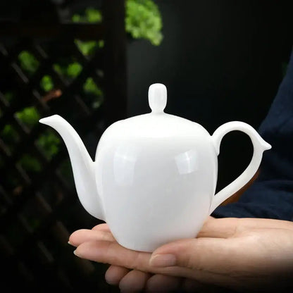 White ceramic teapot pouring tea