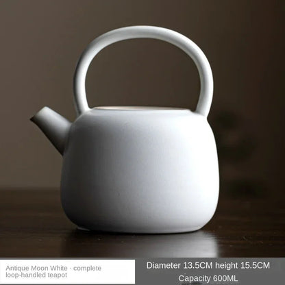 Elegant white Chinese ceramic teapot displayed on a rustic wooden shelf