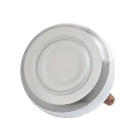 Flat magnetic base of white whistling kettle for induction stove compatibility