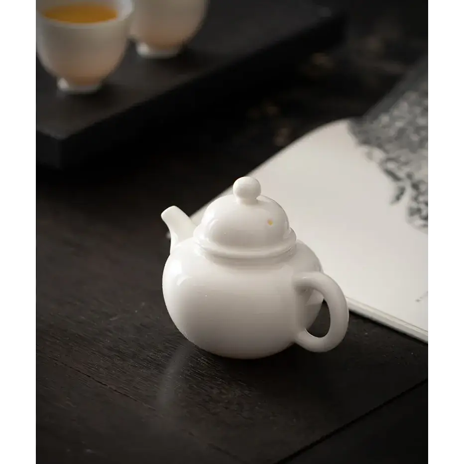 Handmade white ceramic teapot with cup
