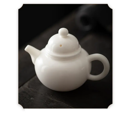 White porcelain teapot with cup and saucer