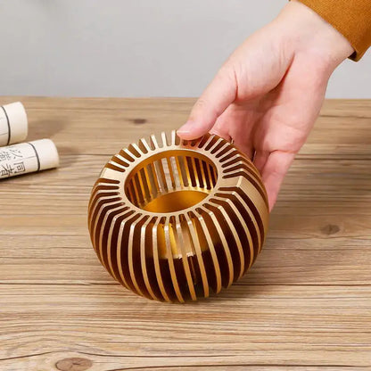 Decorative teapot warmer with geometric cut-out pattern, gold finish detail