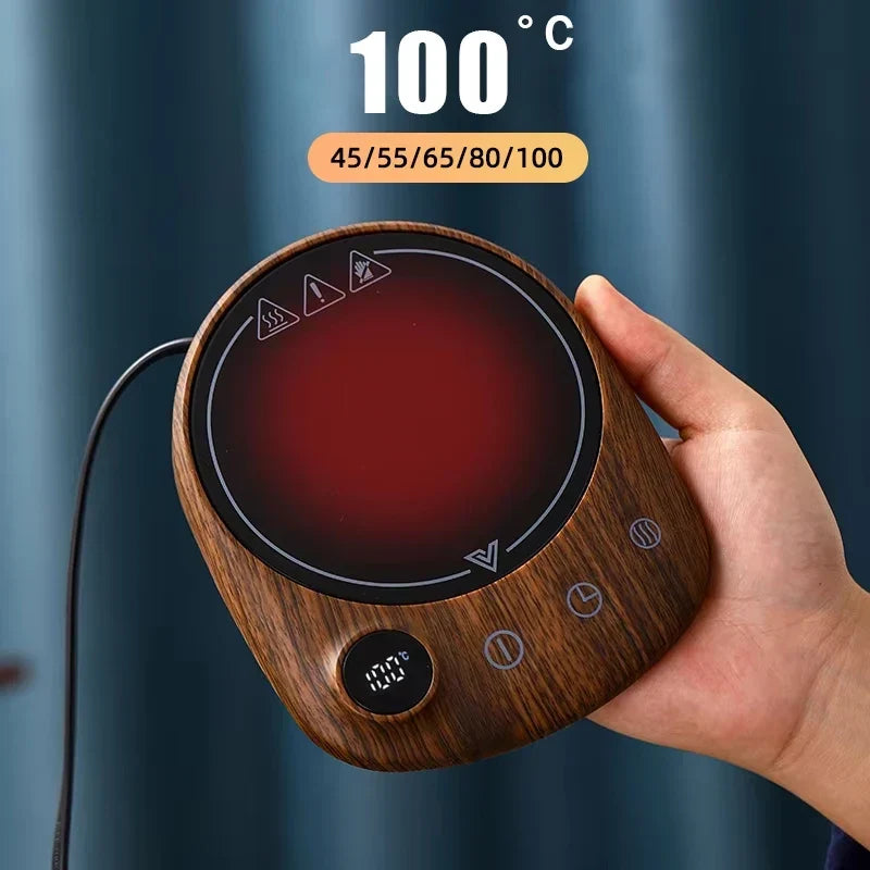 Electric mug warmer heating a ceramic tea mug on a desk