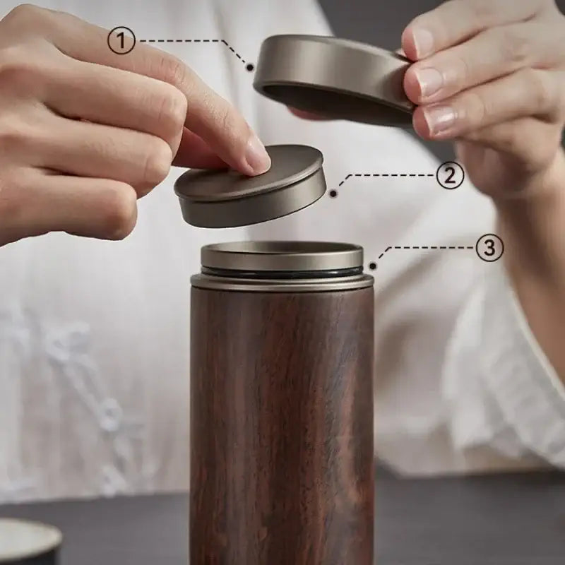 Open handcrafted wooden tea caddy showing divided compartments with loose leaf tea
