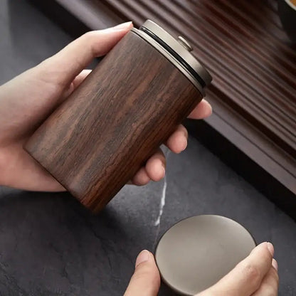 Wooden tea box for tea storage placed on a kitchen counter next to a kettle