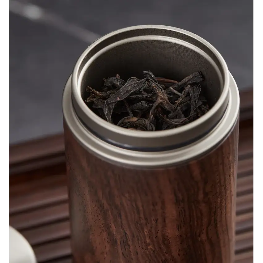 Wooden tea storage box with loose leaf tea and wooden spoon beside it
