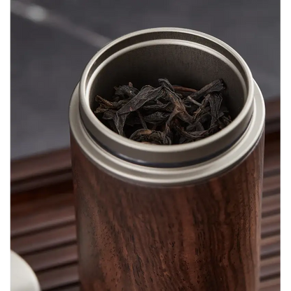 Wooden tea storage box with loose leaf tea and wooden spoon beside it