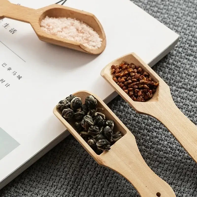 Close up of a wooden tea spoon with tea leaves