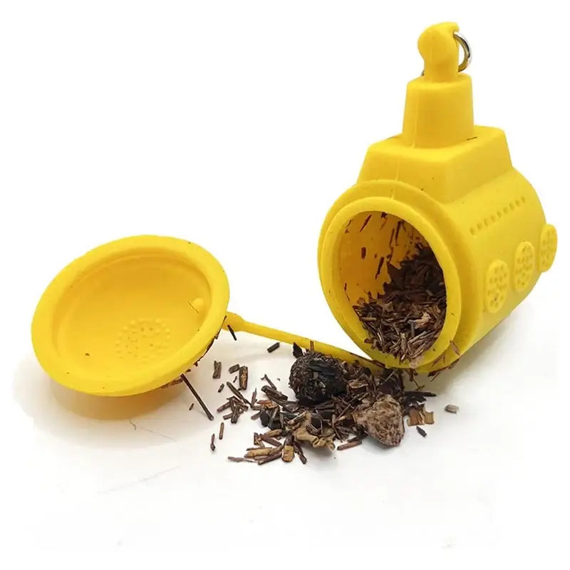 Submarine tea infuser sitting on a saucer next to a teacup