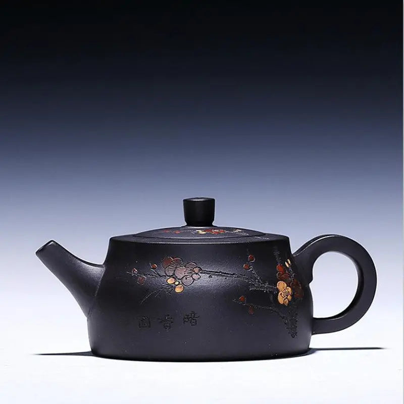 Black Yixing clay teapot with hand-carved flower motif, matte zisha finish