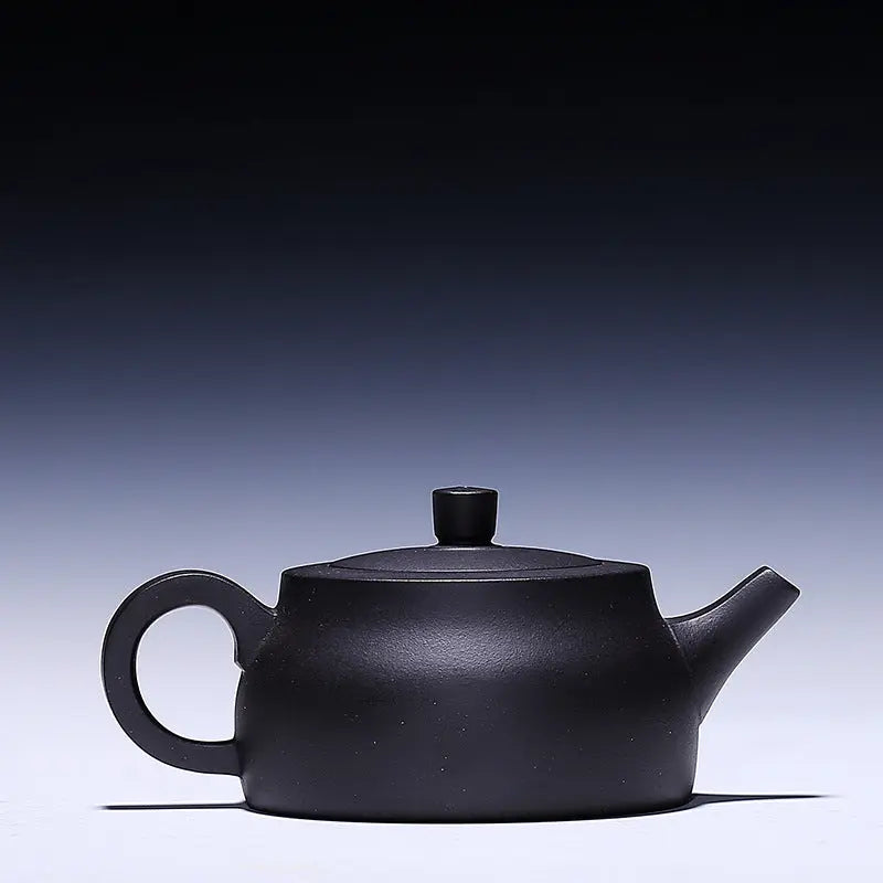 Close-up of hand-applied flower motif on black Yixing zisha teapot surface
