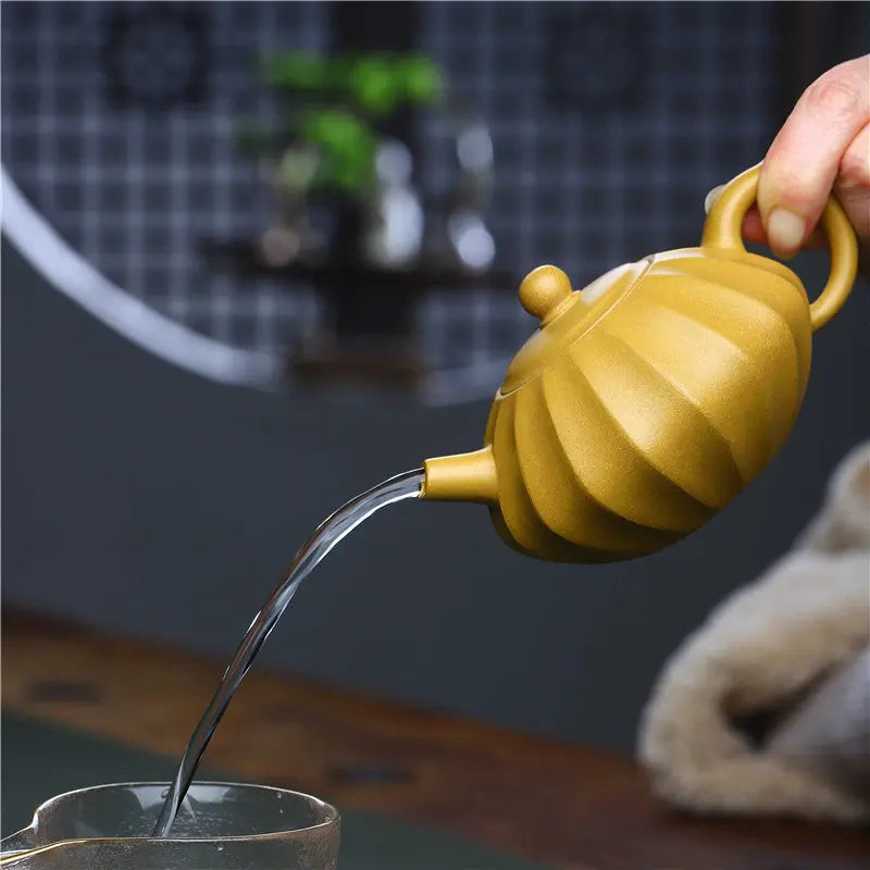Yixing clay teapot used for gongfu cha brewing, small cups and loose leaf oolong