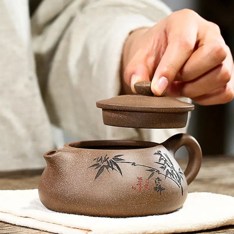 Front view of unglazed Yixing purple clay teapot with bamboo carving, 230ml