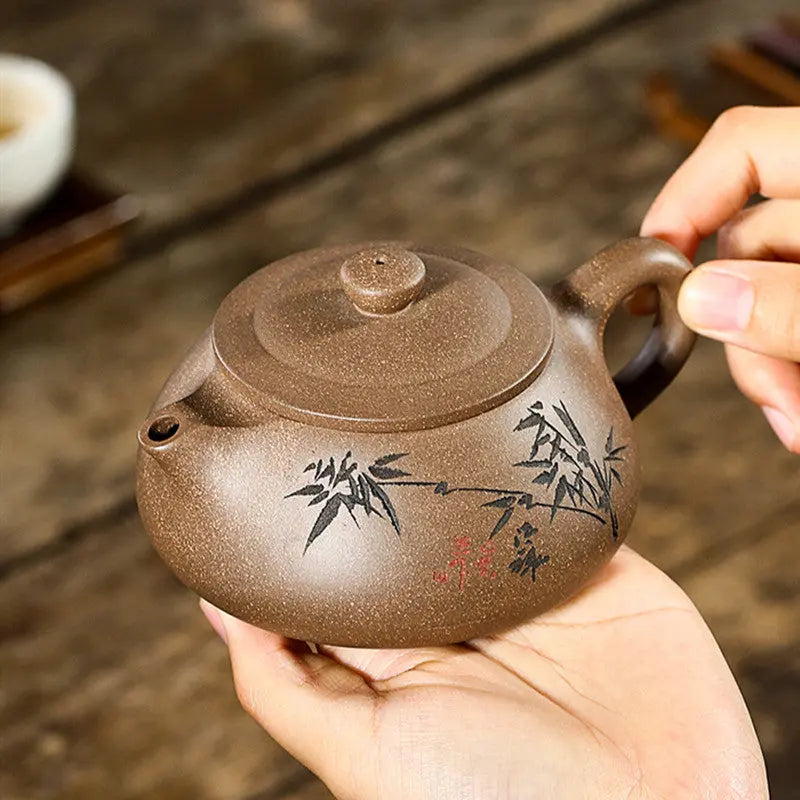 Side angle of Yixing zisha teapot showing bamboo motif and natural clay texture