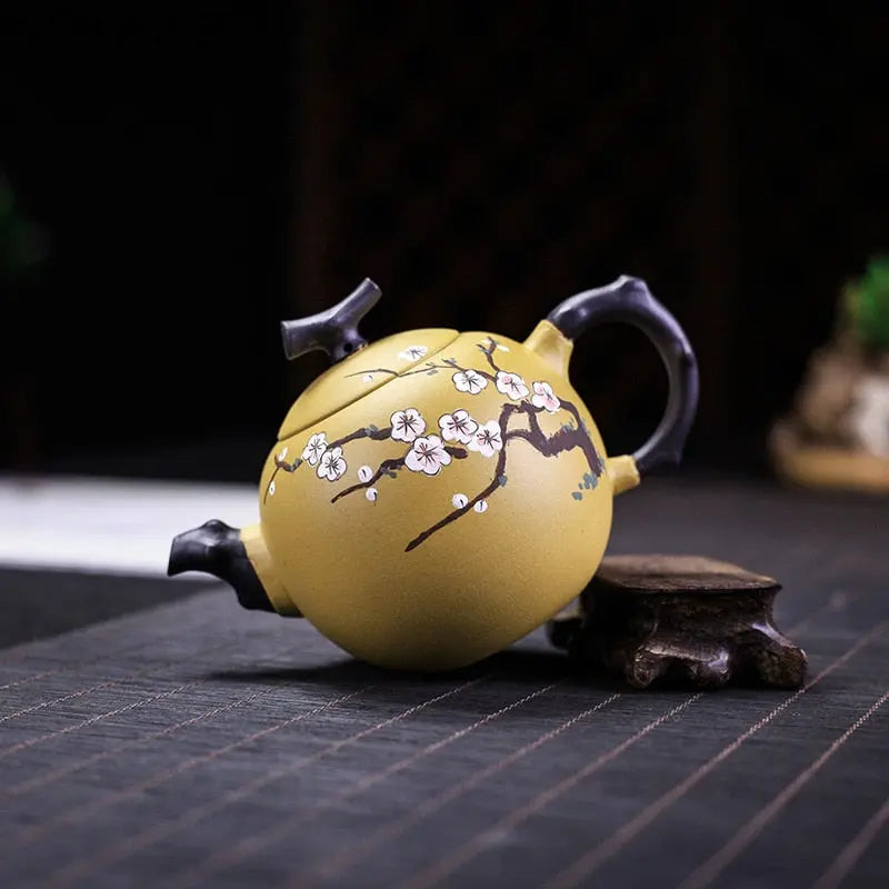 Close-up of hand-carved cherry blossom design on unglazed Yixing zisha teapot