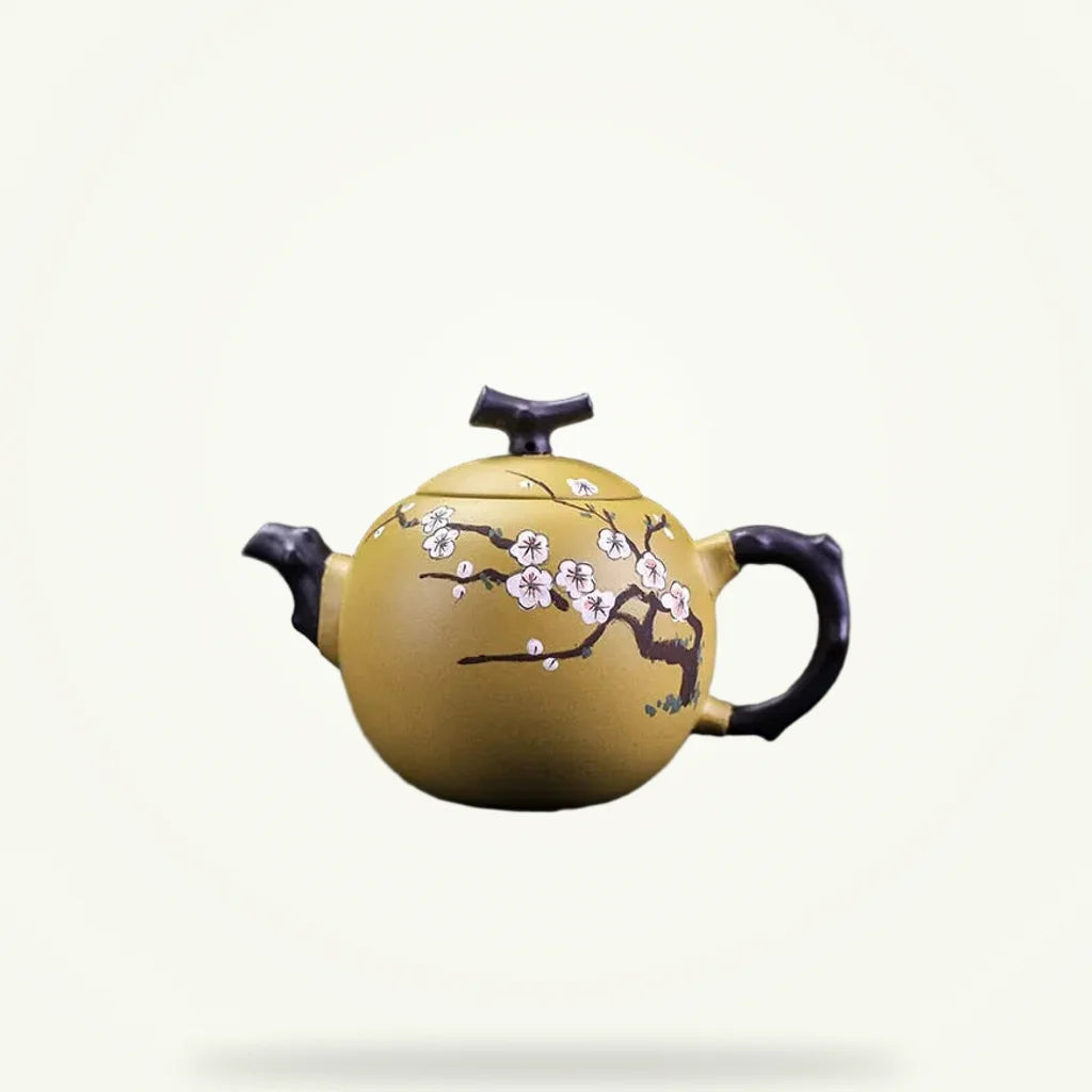 Yixing clay teapot with cherry blossom motif 250ml on plain background, golden zisha clay