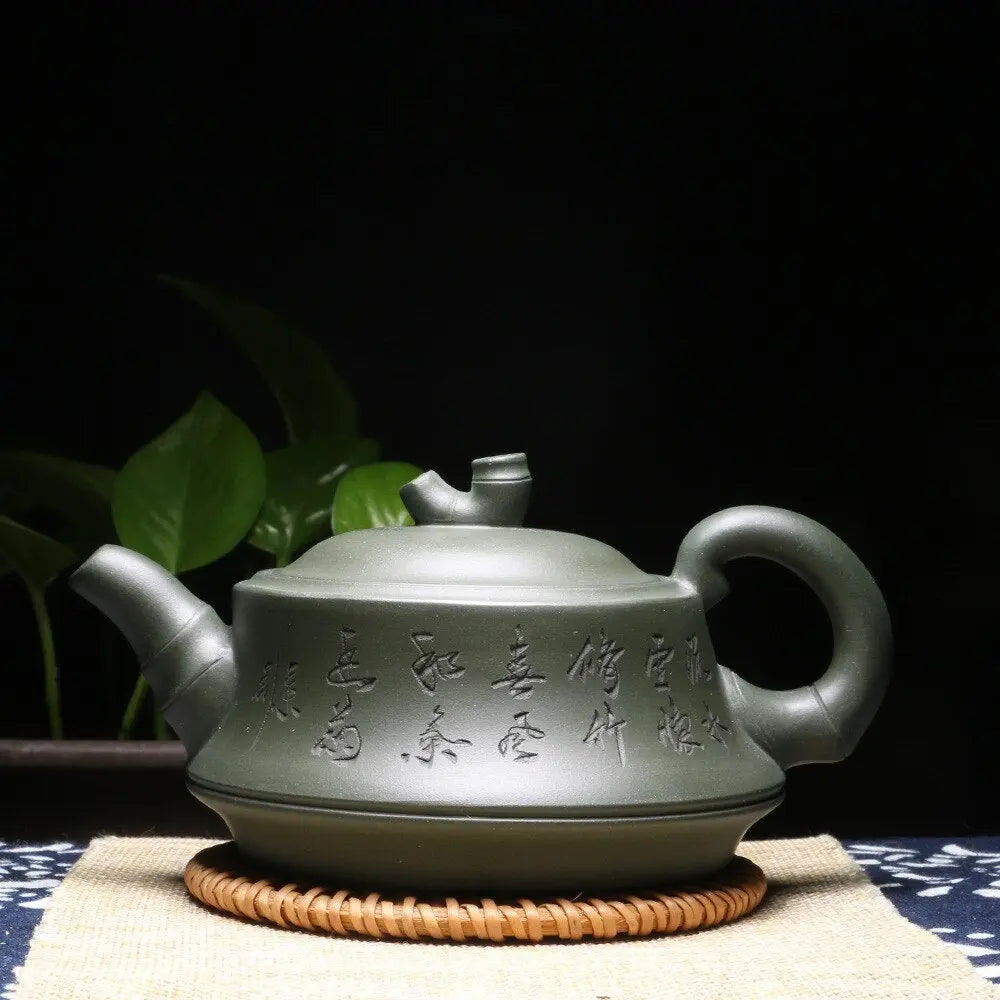 Handmade Yixing zisha teapot showing calligraphy detail, side angle