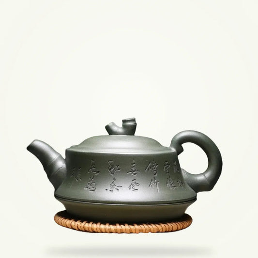 Yixing clay teapot with Chinese calligraphy 240ml on plain background, front view