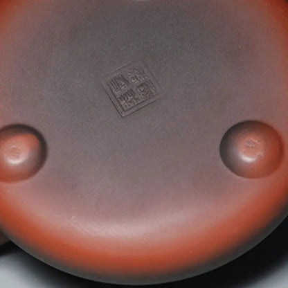 Yixing teapot with traditional symbols on wooden tray, gongfu tea setting